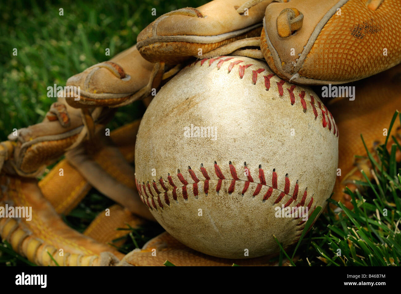 Old American Baseball And Leather Catchers Glove On A Grass Background
