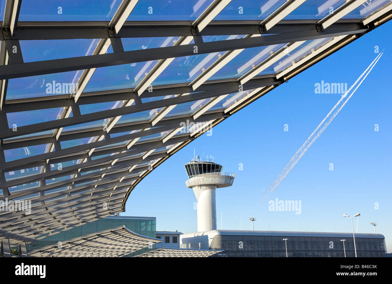 modern construction with airport control tower and airplane line in blue sky Stock Photo