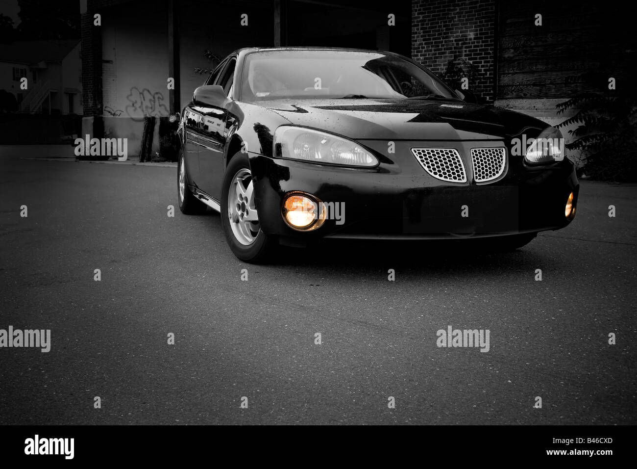 A modern sports sedan with selective color parked in an urban setting