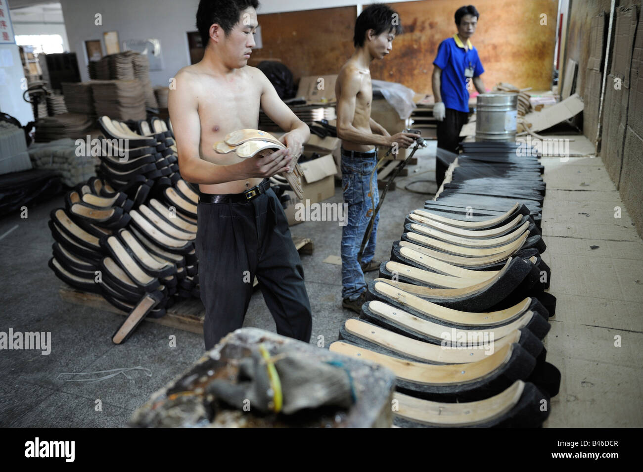 Laborers spray glue for office chairs at a Taiwan capital furniture