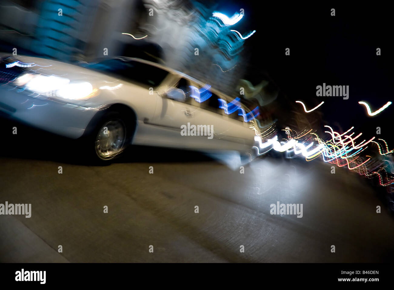An abstract blur of a white limousine in the city at night with light trails Stock Photo