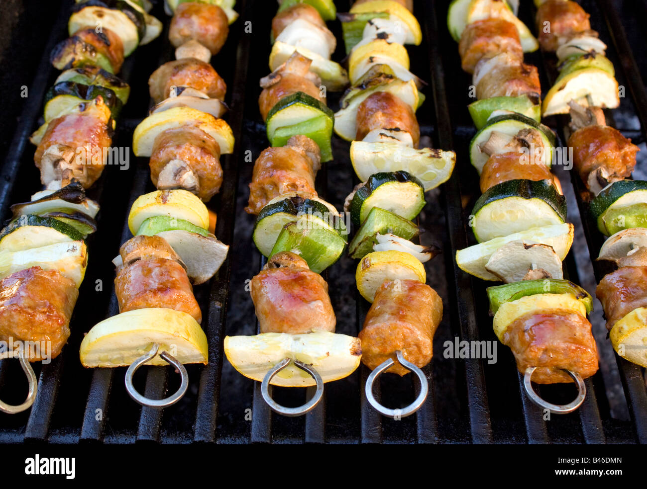 Sausage shish kebabs on skewers cooking on the grill Stock Photo Alamy