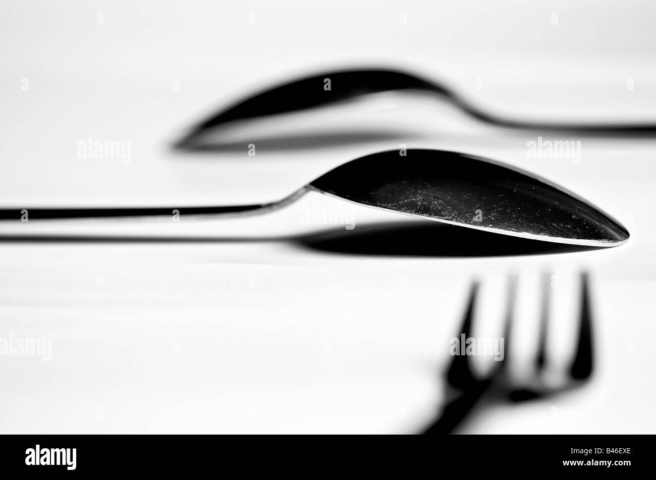 two spoons and a fork on a white table Stock Photo