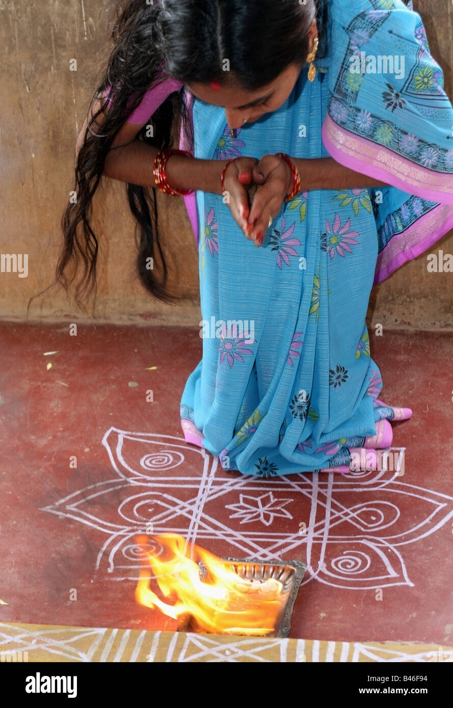 Indian lady blessing her home with arti fire pooja during Vishwakarma Ayudha Puja ceremony , India Stock Photo