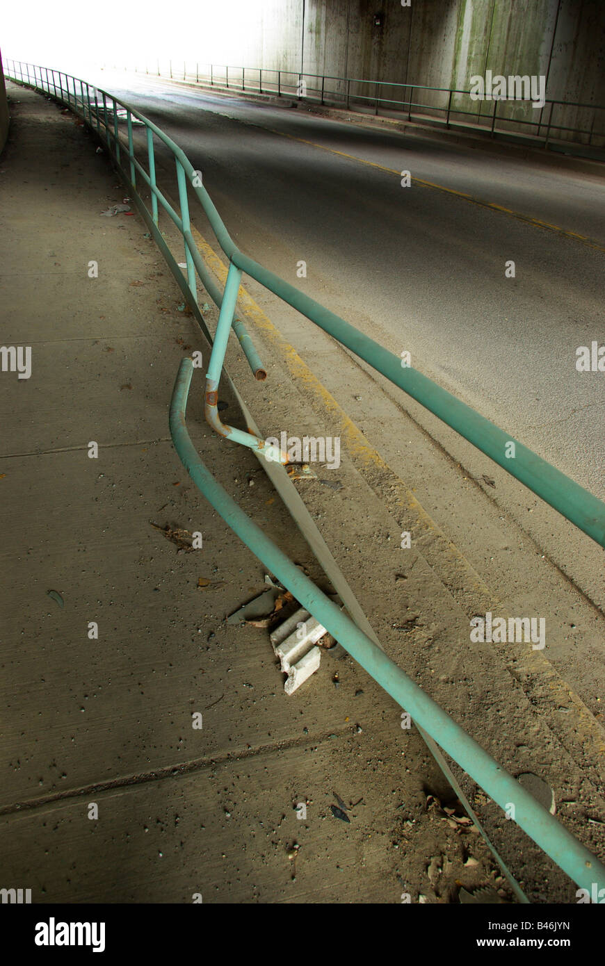 Damage to a railing on a pedestrian area under a railroad bridge from a car accident Stock Photo