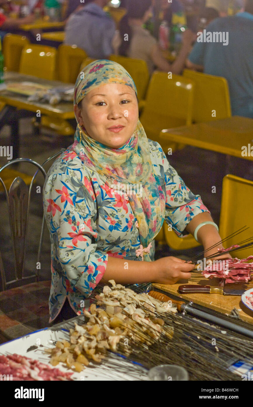 Muslim Woman Making Shashlik at the Night Market in Jiayuguan in Gansu Province China Stock Photo
