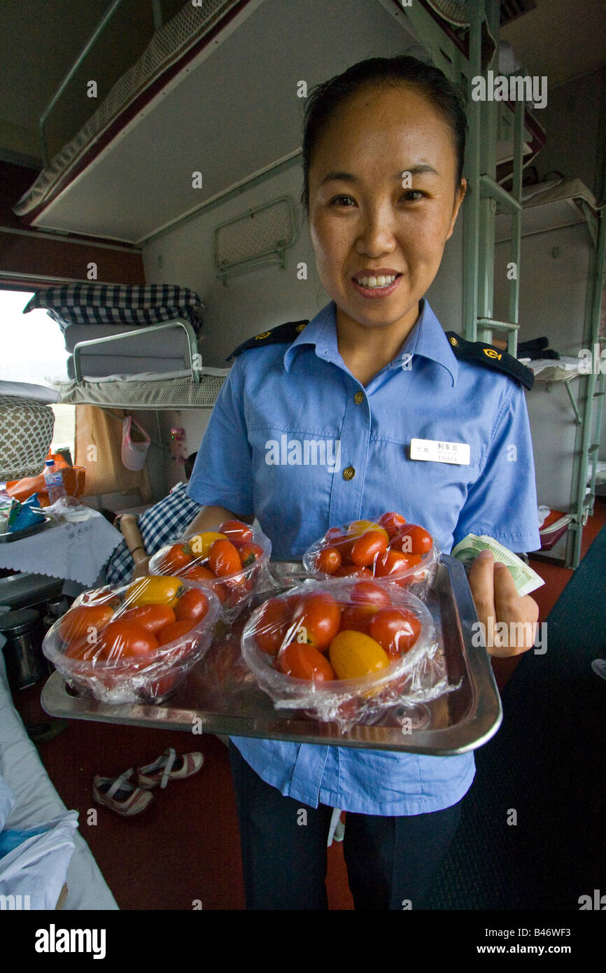 Train Attendant Selling Tomatoes on a Chinese Sleeper Train Stock Photo