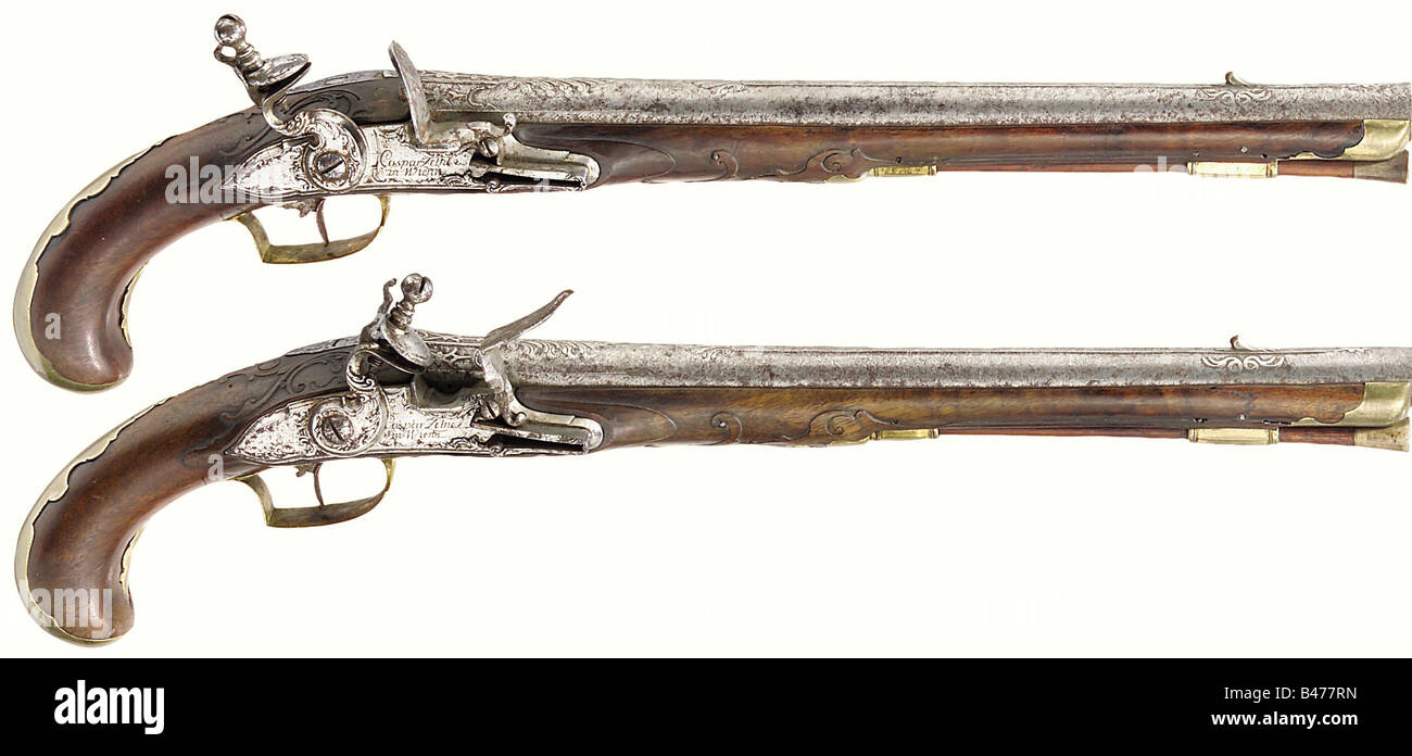 A pair of flintlock pistols, South German, ca. 1730/80. Long Damascus barrels with smooth bores in 16 mm calibre, the top sides with chiselled palmette ornamentation and silver inlays. The tangs numbered '1' and '2' respectively. Finely engraved locks with the signature 'Caspar Zellner in Wienn'. Fullstocks with carved vine ornamentation. Smooth brass furnitures. Wooden ramrods with horn tips. Length of each 49.5 cm. A pair of pistols assembled around 1780, making use of earlier barrels and locks from around 1730. historic, historical, 18th century, civil handg, Stock Photo