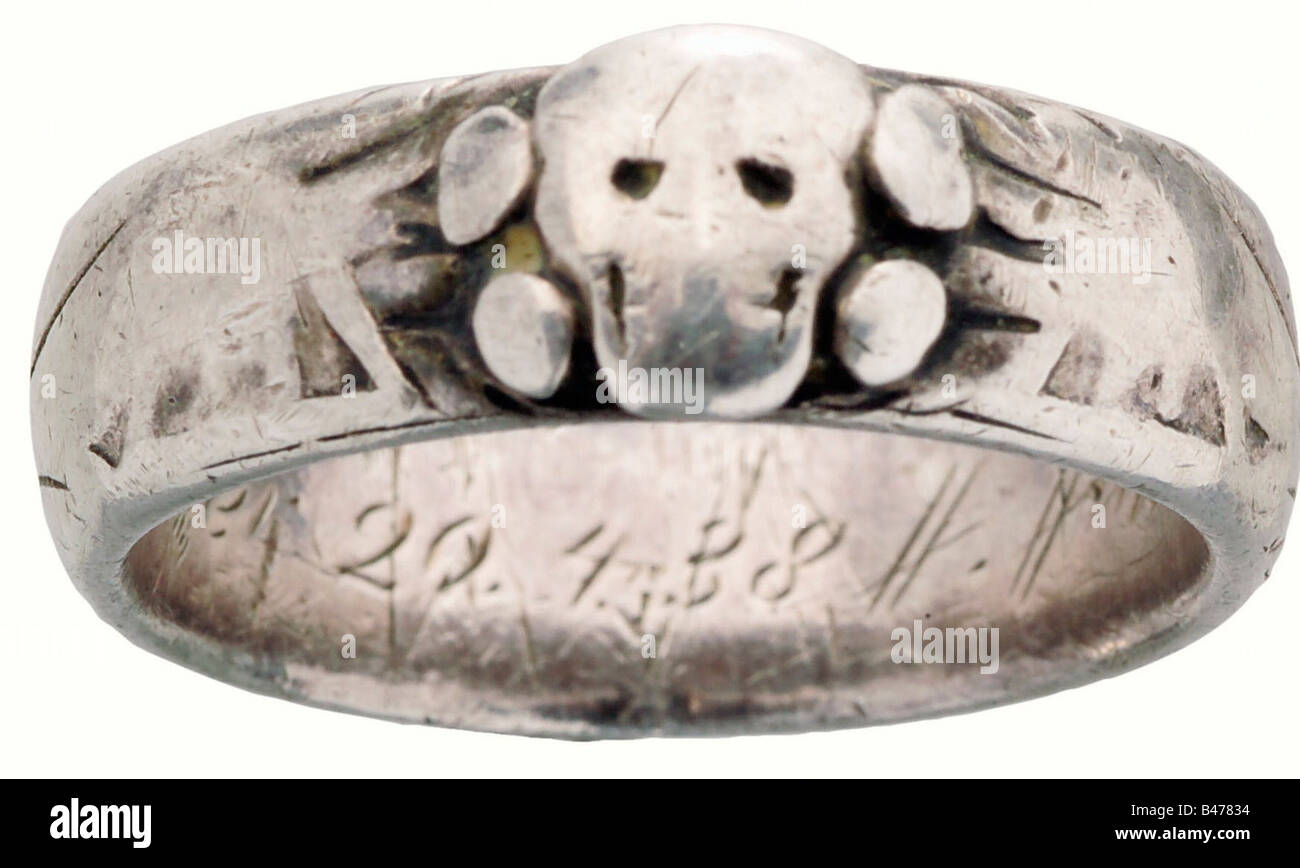 An SS death's-head ring., Silver. Made to measure by the Gahr Jewellers in Munich, soldered together beneath the separately applied death's head. Has a dedication engraving on the inside, 'S. lb. von Weppeler 20.4.38 H. Himmler' (To his well-beloved von Weppeler 20 April 1938 H. Himmler). Weight: 7.6 g. Heavy wear marks. The exterior is almost entirely effaced. Includes a photo appraisal by Detlev Niemann. historic, historical, 1930s, 20th century, Waffen-SS, armed division of the SS, armed service, armed services, NS, National Socialism, Nazism, Third Reich, G, Stock Photo