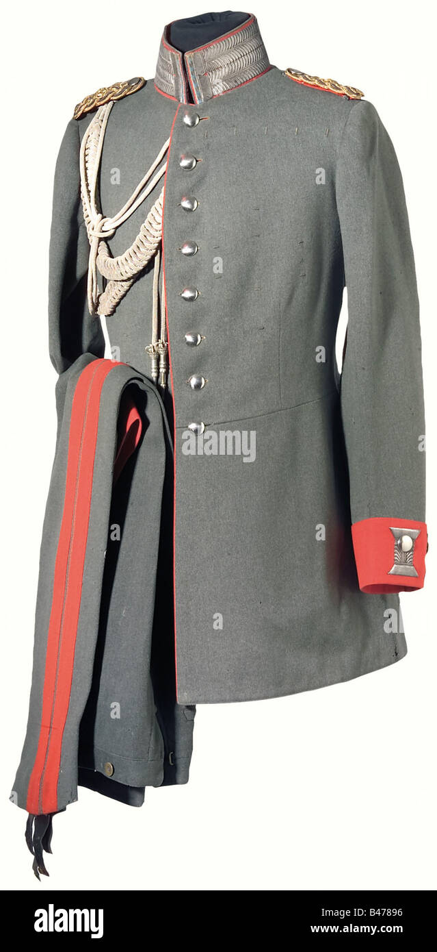 A model 1915 uniform for a General à la suite., Coat of field grey wool tricot with aiguillette and a ponceau red collar, shortened lozenge shaped braid on the forward edge and the special silver embroidery, ponceau red lace and Swedish cuffs with silver embroidery. All buttons shiny silver. The interwoven gold/silver shoulder boards have gilded crowns and are backed with ponceau red slip-on sleeves. Numerous order loops. Field grey/light grey artificial silk lining. The interior pocket has the tailor's label with wearer's nametag. General's cloth trousers of f, Stock Photo