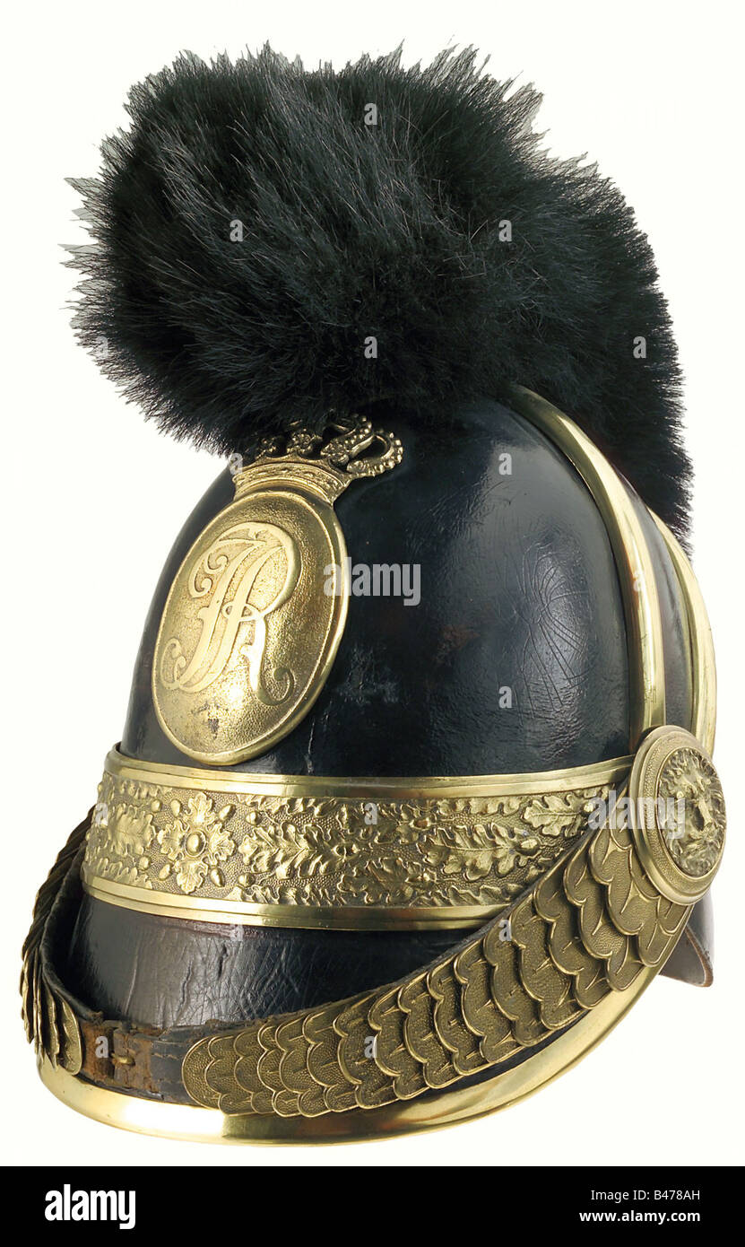 Saxony: A helmet of 1843 pattern for officers, of horse artillery, as worn until 1867. A leather skull with lateral reinforcing bands, adorned by a plate bearing the cypher 'IR' (King Johann, 1854 - 1873), with a brass band with oak leaf pattern ornament beneath it. A crest of horsehair (some of the attachment fittings are replacements). Chinscales with stamped ornament are attached to lion's head bosses. The liner is missing. Size 54. historic, historical, 19th century, object, objects, stills, clipping, clippings, cut out, cut-out, cut-outs, helmet, helmets, , Stock Photo
