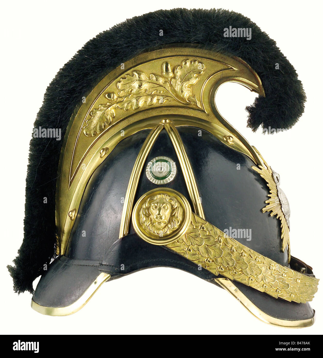 Saxony: A helmet of M 1867 pattern for officers, of heavy cavalry. A leather skull with gilt mountings, topped with a comb with embossed oak leaf ornament. The plate consists of an eight-pointed star overlaid with a coat of arms. Profiled chinscales are secured to lion's head side bosses, a state cockade is rivetted to the right side. On the inside, the sweatband shows some signs of ageing. Size 56. A rare helmet in an excellent state of preservation. historic, historical, 19th century, helmet, helmets, headgear, headgears, protection, protective, uniform, unif, Stock Photo