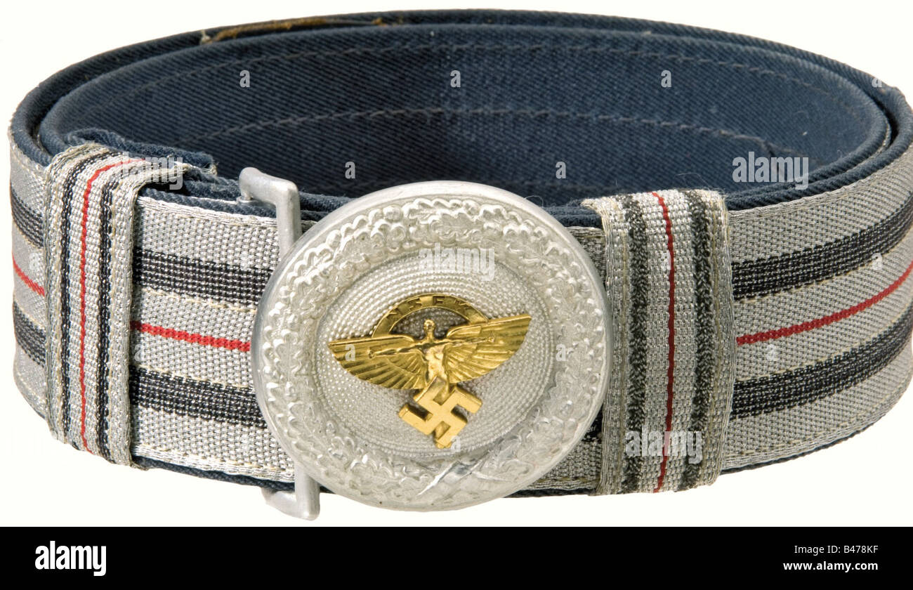 A buckle for a field service belt for an NSFK Leader., Oval aluminum buckle with a riveted, gold plated NSFK eagle. Maker 'RZM M4/24/4'. It comes with the brocade belt of aluminum thread with red pinstripe in the middle, and two blue black interwoven stripes on the outside. Blue gabardine backing. Leather tongue (imperfections). The belt catch is missing, the two slides are dissimilar. historic, historical, 1930s, 1930s, 20th century, organisation, organization, organizations, organisations, object, objects, stills, clipping, clippings, cut out, cut-out, cut-ou, Stock Photo