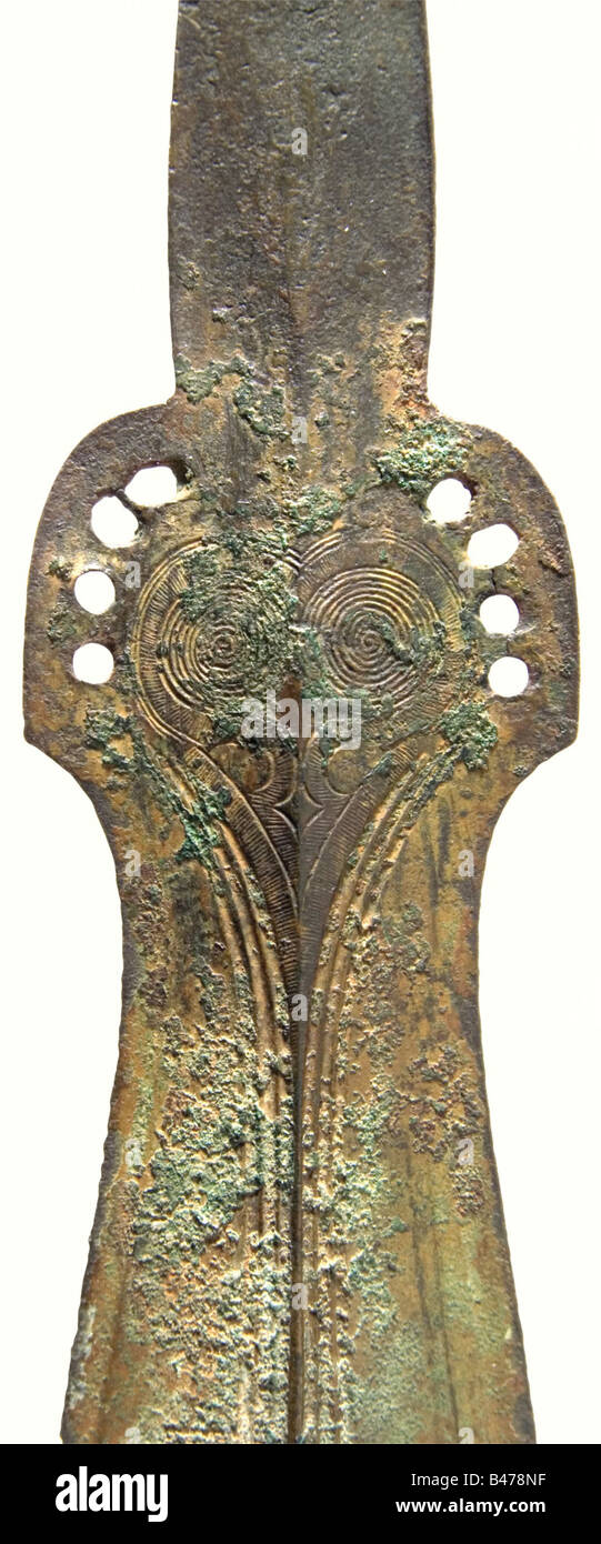 A bronze sword, Central Europe, Bronze Age, circa 1200 B.C. Bronze with greenish patina. Long, slender blade with a pronounced mid-ridge on both sides. Small notches in the edges. The upper fourth of the blade broadens and bears several fullers. The ricasso has finely engraved concentric circle decoration and eight holes for fastening the grip. Flat tang, broadening at the end with a single hole. Cleaned excavation discovery. Length 83.5 cm. historic, historical, ancient world, ancient world, ancient times, object, objects, stills, clipping, cut out, cut-out, c, Stock Photo
