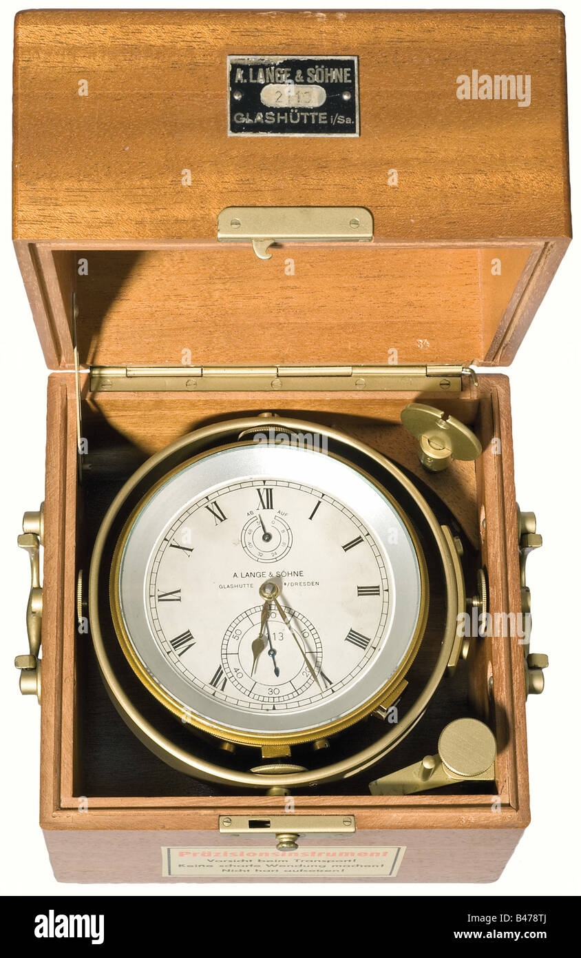 A navy ship's chronometer, A. Lange & Söhne, Glashütte. Standard chronometer, as in use with the Kriegsmarine, no. '2113' produced after 1949. Oak box, and carrying case. Gimbaled brass bowl, 3 pillar movement with steel belt, spring detent and helical hairspring. Silver-white dial with black cyphers, pear shaped golden hands, subsidiary second and power reserve indicator. On the wooden box etched lable 'A. Lange & Söhne 2113 Glashütte i/Sa'. Early post war chronometer with spring detent (numbers of the 2000 series). historic, historical, 1930s, 20th century, G, Stock Photo
