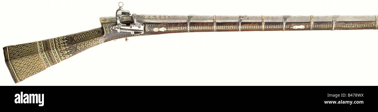 A miquelet flintlock rifle, Ottoman, middle of the 18th century. Octagonal, slightly swamped, twist Damascus barrel with seven-groove rifling in 15 mm calibre with brass front sight and fixed rear sight. Embossed and engraved, vine shaped, silver inlays on the muzzle and breech. Reworked miquelet lock with brass filled maker's marks. Typical 'Tüfeng' stock (repaired break near the lock) with light and green bone inlays and decorated entirely with a variety of brass star rosettes. Nine silver barrel bands. The wooden ramrod is a replacement. Length 117 cm. histo, Stock Photo