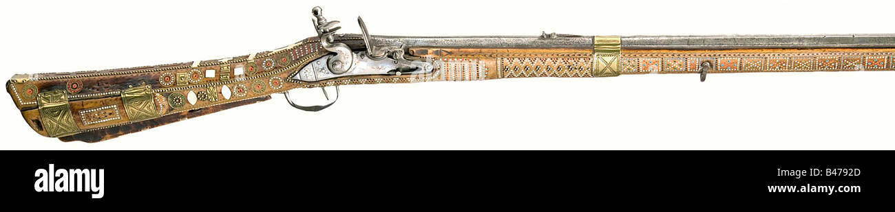 A flintlock musket, Baltic/Carpathian, circa 1800. Octagonal barrel with smooth bore in 12 mm calibre with iron front sight and chiselled rear sight. Iron flintlock with remnants of copper solder on the flat lock plate. Light, birch(?) full stock with the surface completely covered with pieces of bone, corded brass wire, and multi-coloured glass beads. There is a Cyrillic stamp on the back of the patch box cover, 'Lemberg National Museum'. Chased brass barrel and patch box bands with an iron trigger guard. Wooden ramrod with a brass jag. Unusually lavishly deco, Stock Photo