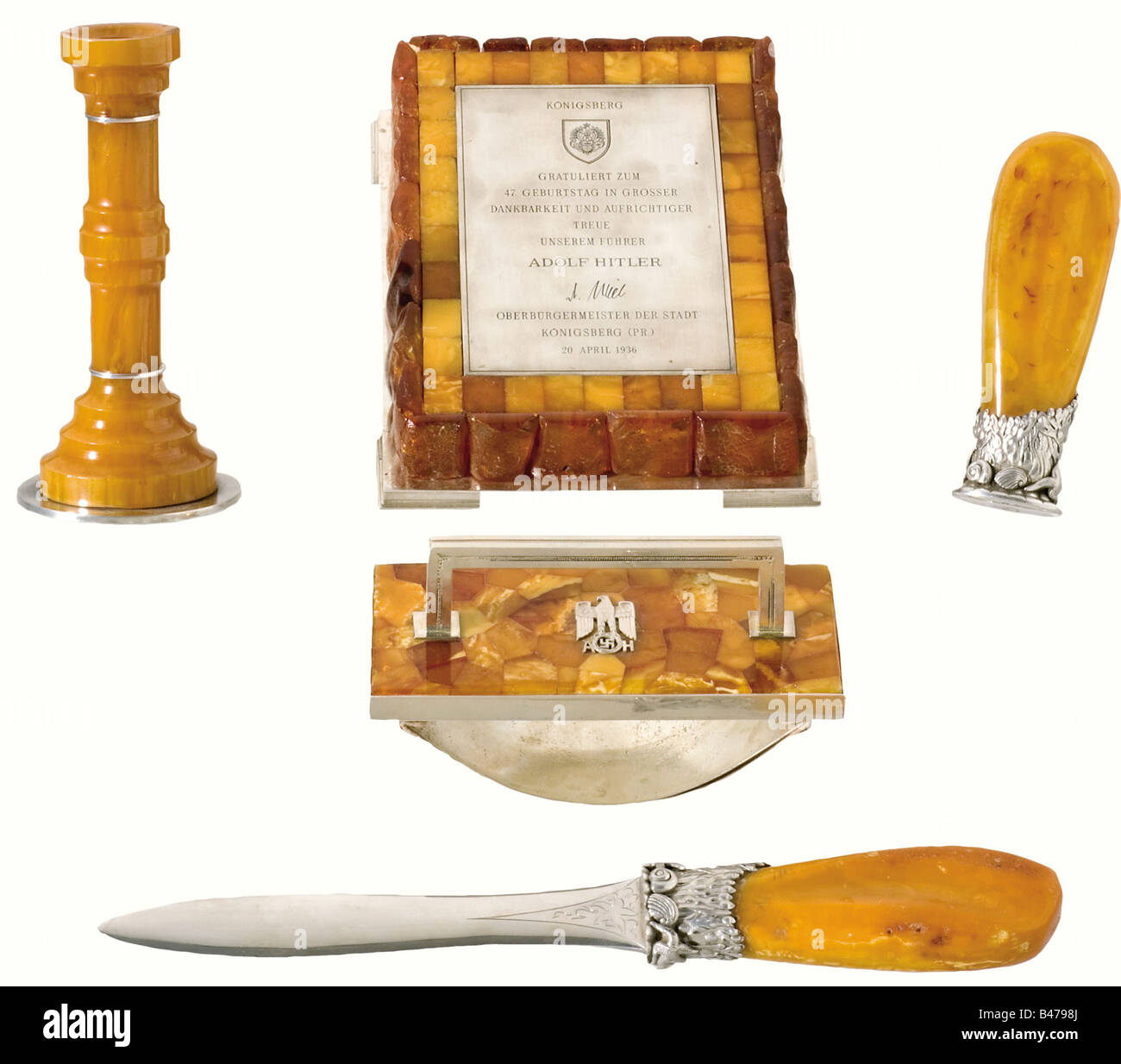 Adolf Hitler - an amber writing desk set., A gift from the City of Königsberg on Hitler's 47th Birthday on 20 April 1936. Silver, amber, and wood, with a silver-plated figure of Atlas. The individual pieces composing the set are: a) a large paperweight with an engraved silver dedication plaque, "Königsberg gratuliert zum 47. Geburtstag in grosser Dankbarkeit und aufrichtiger Treue unserem Führer Adolf Hitler - H. Mill - Oberbürgermeister der Stadt Königsberg (Pr.) 20. April 1936". (Königsberg congratulates our Führer Adolf Hitler on his 47th Birthday in Sincere, Stock Photo