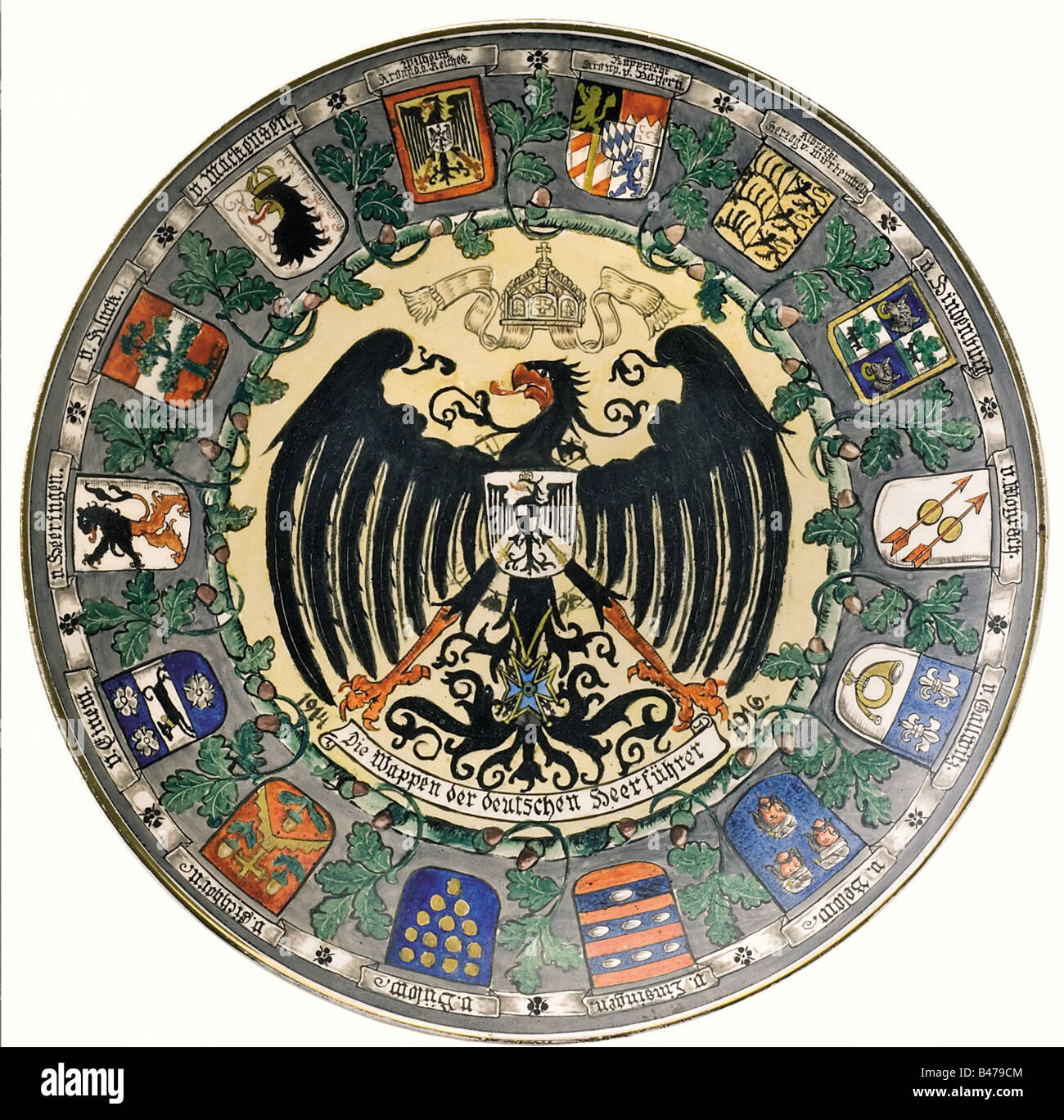 A plate with coat of arms., White glazed porcelain, evenly crackle. Hand-painted, the centre showing the Prussian Eagle under imperial crown, beneath a banner reading 'The coats of arms of the German army commanders' between the dates '1914' and '1916', surrounded by oak leaf decoration. On the border the coat of arms, each with a name banner. The backside with the manufacturer mark 'Villeroy & Boch Dresden' in underglaze brown and press mark. Diameter 36 cm. fine arts, 1910s, 20th century, First World War / WWI, world war, world wars, military, milit, Artist's Copyright has not to be cleared Stock Photo