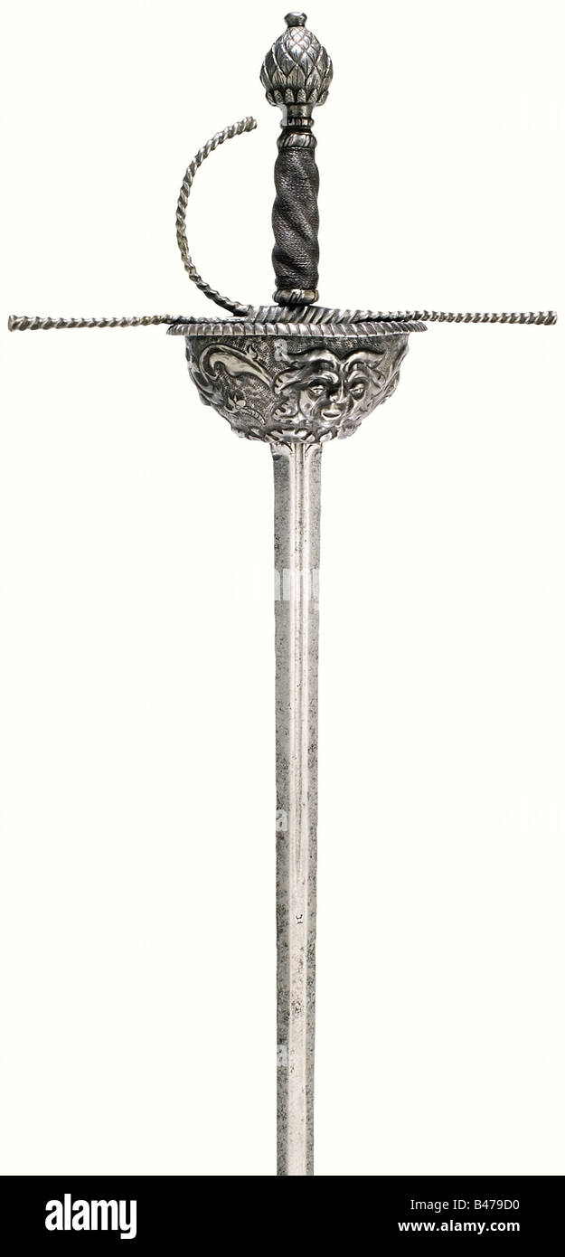 A cup-hilted rapier, Spanish, middle of the 17th century. Double edged blade of flattened octagonal section with smith marks on both sides. The relief embossed, iron cup guard, has a rosette plate on the bottom and vine decorated grotesque masks on the sides. Spirally chiselled, slightly conical quillons with one loop guard. Original iron wire grip wrapping with a pommel chiselled in the shape of a pine cone. Cup and grip cover are somewhat loose. Length 113 cm. historic, historical, 17th century, sword, swords, weapons, arms, weapon, arm, fighting device, mili, Stock Photo