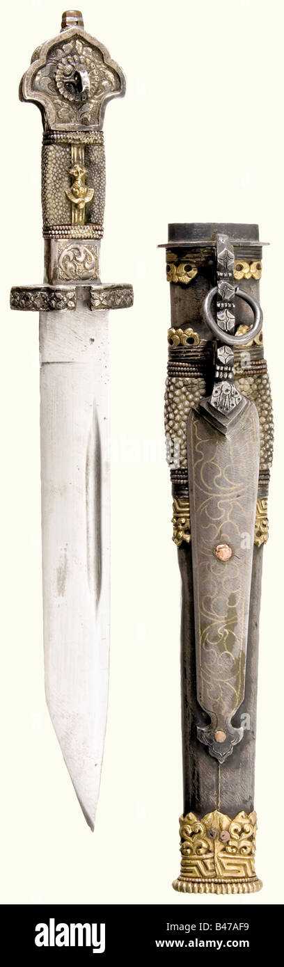A silver-mounted dughti, Tibet, circa 1900 A blade with fullers on both sides and brass and copper-inlaid marks on the obverse side. The silver-mounted and partially gilded grip is embossed with floral designs. Rayskin grip cover, set with coral on the obverse side. The iron scabbard is decorated with brass-inlaid dragons, rayskin, and gilded silver mountings, and a chiselled iron bar with a suspension ring on the reverse side. Beautiful quality. Length 36.5 cm. historic, historical, 1900s, 20th century, 19th century, Far East, Far Eastern, weapon, arms, weapon, Stock Photo