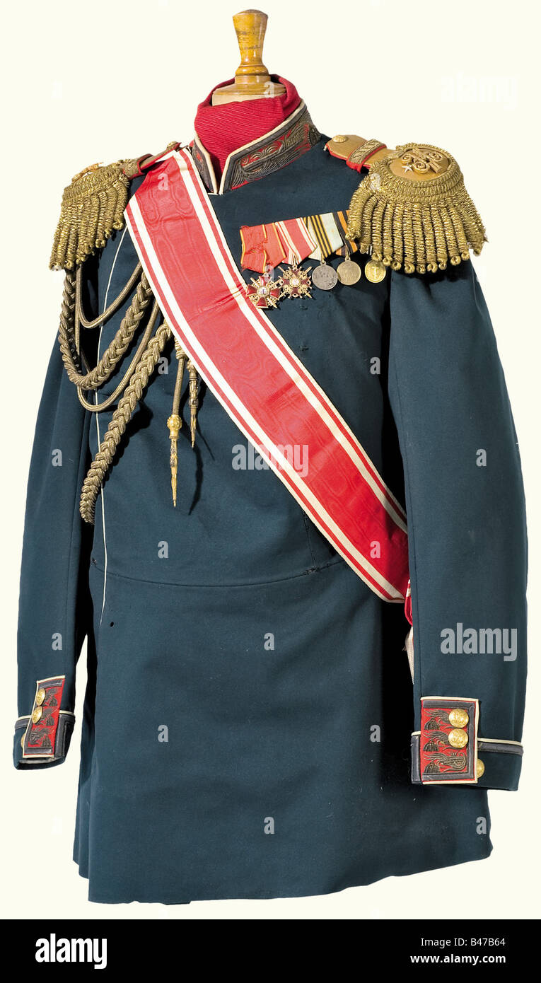 A tunic for a staff officer, during the reign of Tsar Nicholas II The tunic is of heavy blue/green cloth, collars and cuffs are trimmed with red backing, white lace, and gold embroidery. A button flap with five flat gilded buttons. Staff officer's epaulettes with red backing, and gold fields bearing two gilded rank stars and a massive, crowned cipher 'N' for Nicholas II, gold embroidered bullion crescent, and loose gold franges. Aiguillette woven of gold on the right side, the gilded point bearing the silver cipher of Alexander III. The sash of the Order of St., Stock Photo