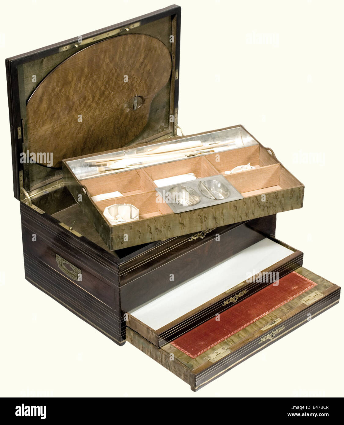Sophie-Marie Duchess of Baden - a traveling paint box, Deforge & Carpentier, Paris, circa 1880. Lavishly worked walnut case with several levels and with surrounding brass bands. Ornamental brass inlays in Boulle technique on the lid, displaying the ducal coronet above an alloy 'SM'. In the lid, a (slightly cracked) palette of bird's-eye maple. Inside a removable box with an iron water container, a porcelain mix holder, a brush, and a variety of large, ivory painting surfaces. In front and on the side there are two lockable drawers with colours, charcoal pencils, Stock Photo
