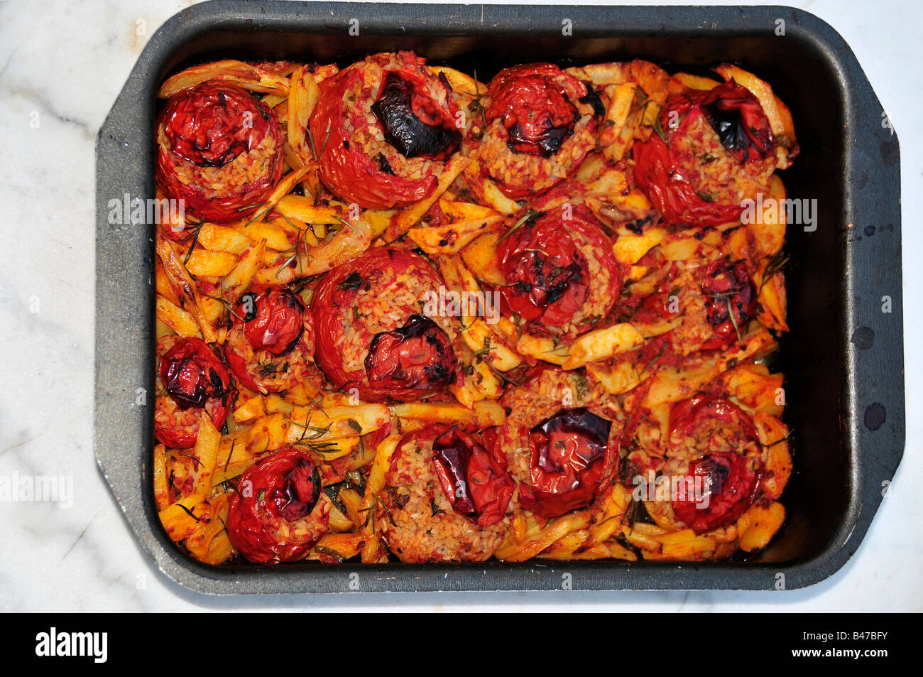 pan of rice-stuffed tomatoes cooked in the oven italian style Stock Photo