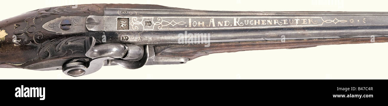 A pair of percussion pistols, Johann Andreas Kuchenreuter, Steinweg bei Regensburg, circa 1780. Blued, smooth bore barrels in 12 mm calibre. Silver front sights and a silver-inlaid signature on the sighting flats. There are four silver-filled marks between inlaid scroll decorations on each of the breeches. The tangs are inscribed "1" and "2". Converted locks with engraved signature. Set triggers. Lightly carved walnut fullstocks. Blank brass escutcheons with the monogram "AM" stamped above them. Smooth brass furniture. Original wooden ramrods with horn tips. Le, Stock Photo