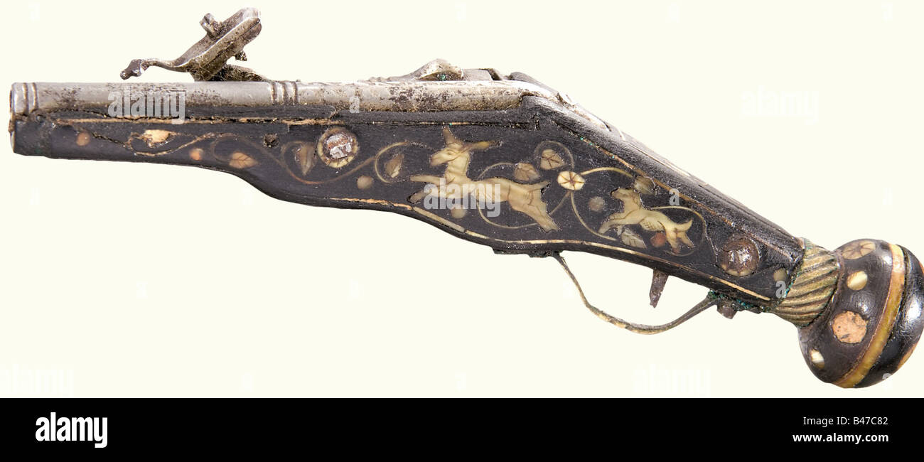 A miniature wheellock pistol, German, presumably 17th century. Octagonal barrel merging to round after a baluster with decorative etching on the front half. Etched lock, loose pan cover. Walnut stock with engraved bone inlays of jumping animals, leafy vines, flowers, and dots (almost completely preserved). Brass trigger guard and band. Lock function not tested. Length 100 mm. Beautiful miniature of an Augsburg wheellock pistol at the end of the 16th century. historic, historical, 17th century, civil handgun, civil handguns, handheld, gun, guns, firearm, fire ar, Stock Photo