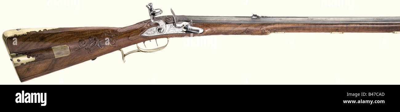 A flintlock rifle, Lorenz Ill, Augsburg, circa 1740. Earlier octagonal barrel (reblued) with eight groove rifling in 10 mm calibre, with two-piece folding dovetailed sights. Stamped, 'MATHIAS STÄDT ANNO 1660' on the breech. Flintlock chiselled with hunting decoration and bearing the signature, 'LORENZ ILL IN AUSBURG'. Set trigger. Walnut full stock with vine carving, patchbox, horn nose cap, and smooth brass furniture. Wooden ramrod with horn tip. Length 94.5 cm. Lorenz Ill, Augsburg and Munich, known 1720 - 46, Mathias Städt, Innsbruck, known 1669 - 74. histor, Stock Photo