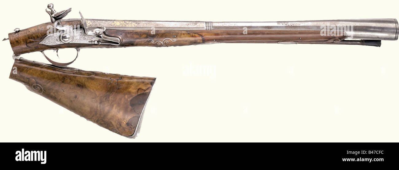 A flintlock blunderbuss, Italian, end of the 18th century. Octagonal barrel merging to round after a baluster with an extended horizontally oval muzzle. Brass inlays on top. Lock with floral engraving (later engraving?), signed, 'D. Donati' with a smooth side plate, bearing the remnants of a belt hook. Folding stock of root wood with silver inlays and iron furniture. The buttstock and forearm have old repairs. The forearm is cracked near one ramrod thimble. Wooden ramrod with horn tip. Length 84 cm. historic, historical, 18th century, civil long guns, gun, weap, Stock Photo