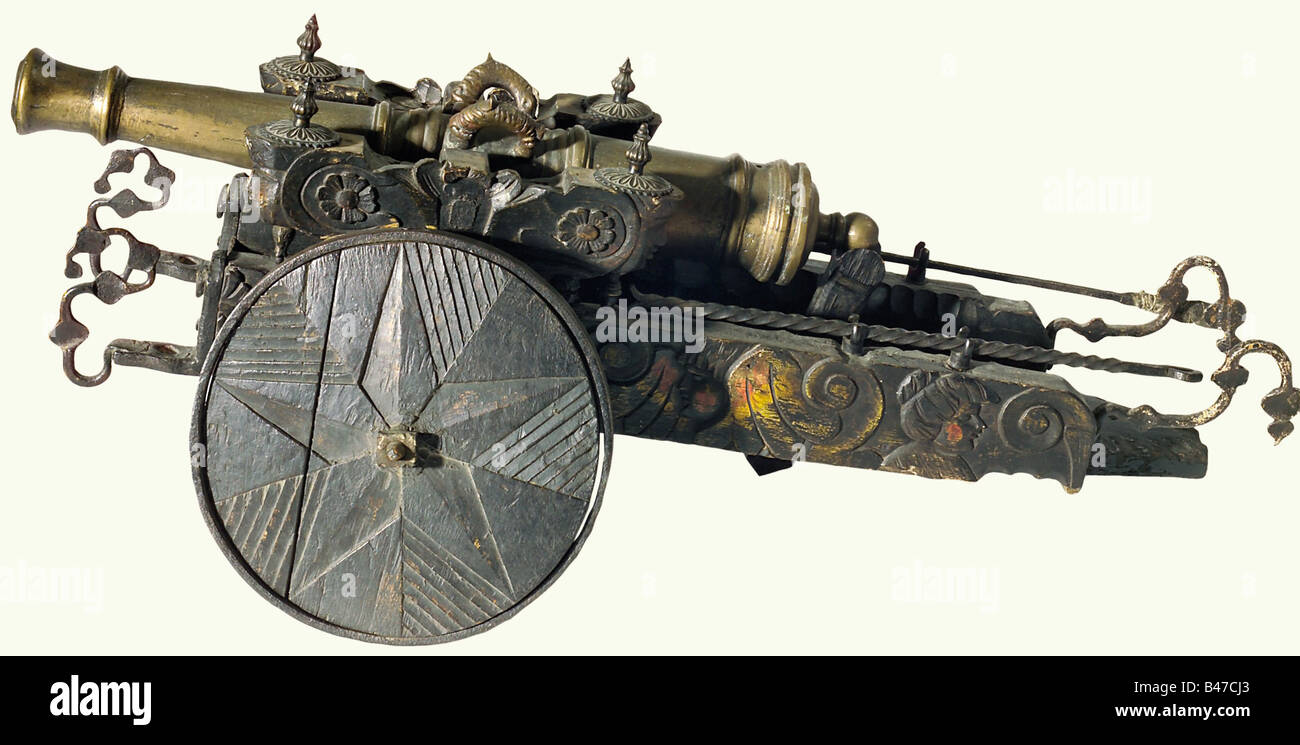A model cannon, China, circa 1900. A heavy bronze barrel with a reinforced muzzle and breech. Touchhole on top with two dolphin-shaped handles. Barrel length 73 cm. Darkly finished, carved wooden carriage with iron furniture, full wooden wheels with star-shaped decoration, and iron loading tools. Total length 112 cm. historic, historical, 1900s, 20th century, 19th century, Far East, Far Eastern, weapon, arms, weapons, arms, military, militaria, clipping, cut out, cut-out, cut-outs, object, objects, stills, Stock Photo