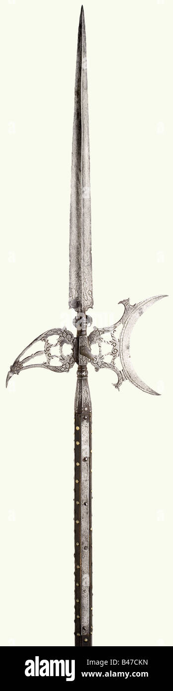 An Italian palace guards halberd, circa 1600. Slender, ridged blade, with surrounding grotesques masks set along the lower edge (one missing). Perforated, crescent moon shaped axe blade and similarly perforated beak. Octagonal socket with long straps beneath a baluster. All parts etched with vine decoration. Original shaft, carved and decorated with brass nails. Iron shoe. Iron parts somewhat stained. Length ca. 250 cm. Interesting halberd 'à la lanterne' in a very beautiful state of preservation. historic, historical, 17th century, pole weapon, weapons, arms, , Stock Photo
