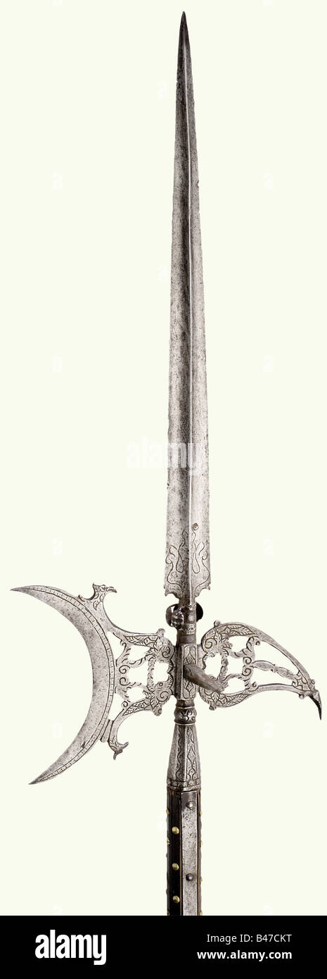 An Italian palace guards halberd, circa 1600. Slender, ridged blade, with surrounding grotesques masks set along the lower edge (one missing). Perforated, crescent moon shaped axe blade and similarly perforated beak. Octagonal socket with long straps beneath a baluster. All parts etched with vine decoration. Original shaft, carved and decorated with brass nails. Iron shoe. Iron parts somewhat stained. Length ca. 250 cm. Interesting halberd 'à la lanterne' in a very beautiful state of preservation. historic, historical, 17th century, pole weapon, weapons, arms, , Stock Photo