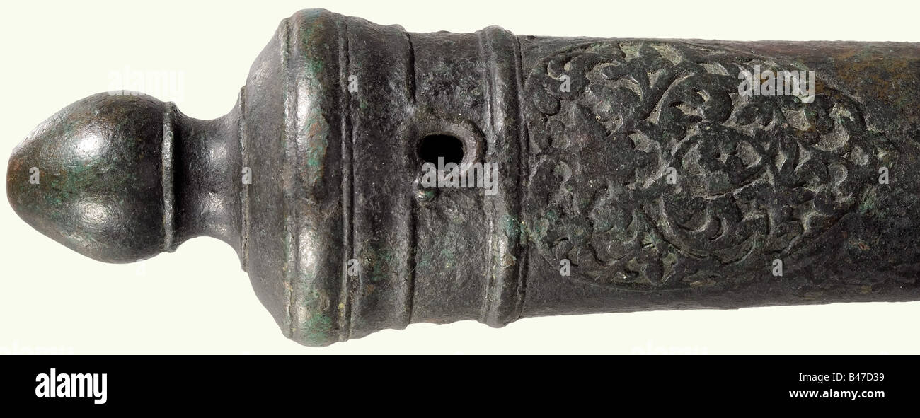 A small cannon barrel, India, 18th century. Bronze 2.4 cm calibre barrel with band structure and a reinforced muzzle. Heavy black/green patina. Two side-mounted trunions. Two dolphins on top. There is a cartouche with relief arabesque ornamentation in front of the touchhole. The breech has a pointed oval cascabel. On a recent oak mount. Length of the barrel 63 cm. historic, historical, 18th century, object, objects, stills, clipping, clippings, cut out, cut-out, cut-outs, weapon, arms, weapons, arms, Stock Photo