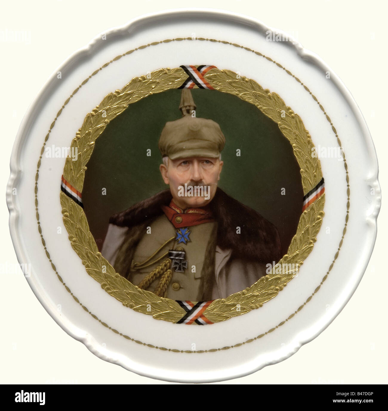 Kaiser Wilhelm II - a KPM plate 1917., A porcelain plate painted in colour with a curved rim and surrounding golden oak leaf decoration in relief. Kaiser Wilhelm II is portrayed in the centre wearing a field grey general's uniform with helmet and overcoat. There are openings in the bottom rim for mounting on a wall, a red KPM mark, a blue scepter mark, a war mark 1914 - 18, and the artist's name, 'Max Dürschke', a painter with the KPM 1898 - 1930. Diameter 26.5 cm. people, 1910s, 20th century, Prussian, Prussia, German, Germany, militaria, military, object, obj, Stock Photo