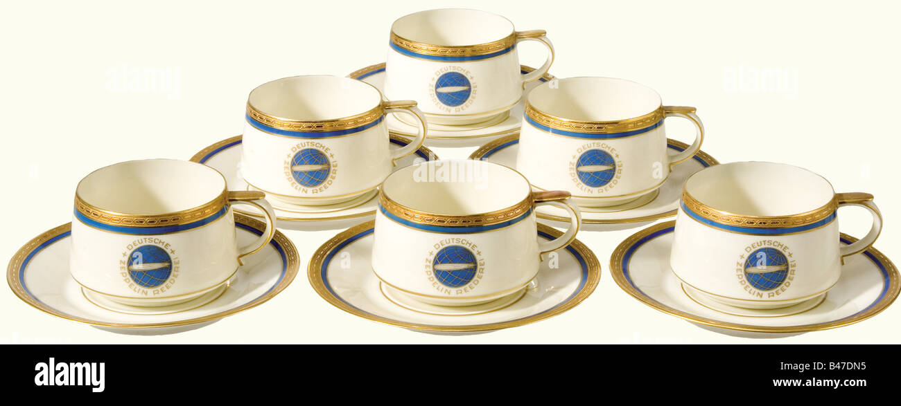 Six mocha cups with saucers, from the German Zeppelin Shipping Line. Etched gold decorative rim set off with blue, and with the blue-gold emblem of the DZR (Deutsche Zeppelin Reederei) on both cups and saucers. Manufacturer's mark on the bottoms, 'Heinrich-Elfenbein-Porzellan Bavaria, Selb' and 'Eigentum der Zeppelin-Reederei' (Property of the Zeppelin Shipping Line). Height of the cups 40 mm. Diameter of the saucers 11 cm. historic, historical, 20th century, transport, transportation, object, objects, stills, dishes, dish, plate, plates, porcelain, chinaware, Stock Photo