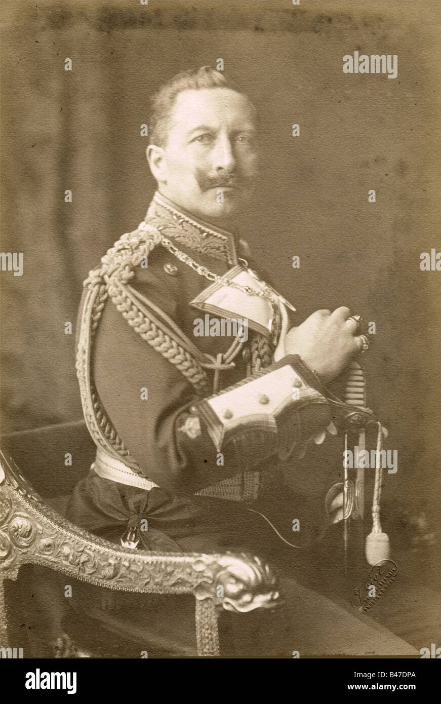 Kaiser Wilhelm II - an aiguillette for his Grand Admiral's uniform., A shoulder knot woven from twisted gold cord, divided into two woven strands, which terminate in crowned golden points. Superimposed with two crossed, gilded Grand Admiral's batons, enamelled red, and white, and with the crowned cipher 'W' on top, the insignia of an aide-de-camp to his grandfather, Wilhelm I. The gilding on the cord and the weave is somewhat worn and darkened. Dark blue cloth backing with two pins and a button-on attachment flap. At the request of the Imperial Navy, Wilhelm II, Stock Photo