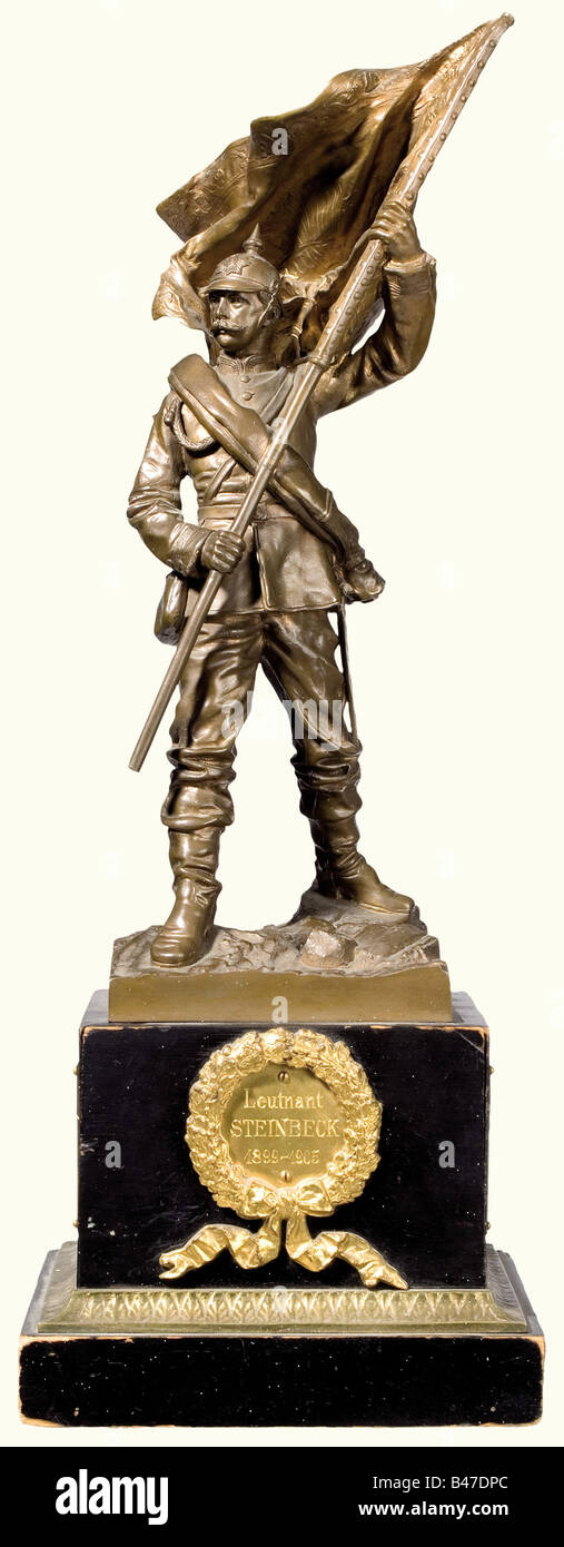 A bronze figure of a standard-bearer of the 7th Royal Saxonian Infantry Regiment No. 106., Farewell gift to 'Leutnant Steinbrück 1899 - 1905'. Standard-bearer with typical field uniform and equipment (flag tip missing), the plinth with monogram 'Dr. L.N. inv. e. del. 95 Lpzg.' and 'Guss v. Pirner & Franz Dresden'. Ebonized wooden base, in the front name plaque with oak leaf wreath, on the back the regimental cipher, on the side plaques with the names of the officer corps. Overall height 39 cm. fine arts, people, 1900s, 20th century, Saxony, Saxonia, S, Artist's Copyright has not to be cleared Stock Photo