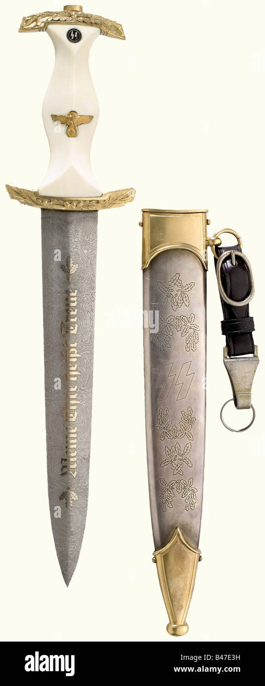 An SS honour dagger., Blade with etched Damascus pattern and the gilded etching of the motto, and on the reverse side with 'Julius Schreck - für höchste Verdienste - H. Himmler' (Julius Schreck - for Greatest Merits - H. Himmler), and runes. Gilded quillons with sculpted oak leaf decoration. White grip with gilded emblems. Silver-plated scabbard engraved with oak leaf decoration and gilded mountings. Leather hanger. Length 34 cm.The breakup of an edged weapons collectionThe pieces offered in this section of the auction were acquired since the post-war years fro, Stock Photo