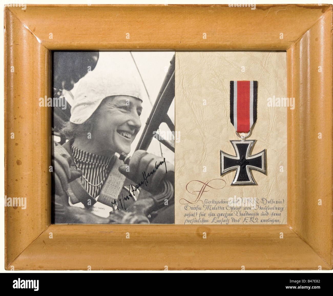 Melitta Countess Stauffenberg - a diorama with photo portrait, in the cockpit of an airplane, with the autograph signature, 'M. Gfn. Stauffenberg', in black ink. Alongside an Iron Cross II Class with the handwritten calligraphic text (transl.), 'Aircraft Captain and D.R.K. (German Red Cross) Auxilary Countess Melitta Schenk von Stauffenberg is awarded the Iron Cross Second Class for her great merits and personal dedication.'. In a leather covered desk frame. Framed dimensions 26 x 31.5 cm. Presumably this is an iron cross from the countess's possessions, which , Stock Photo