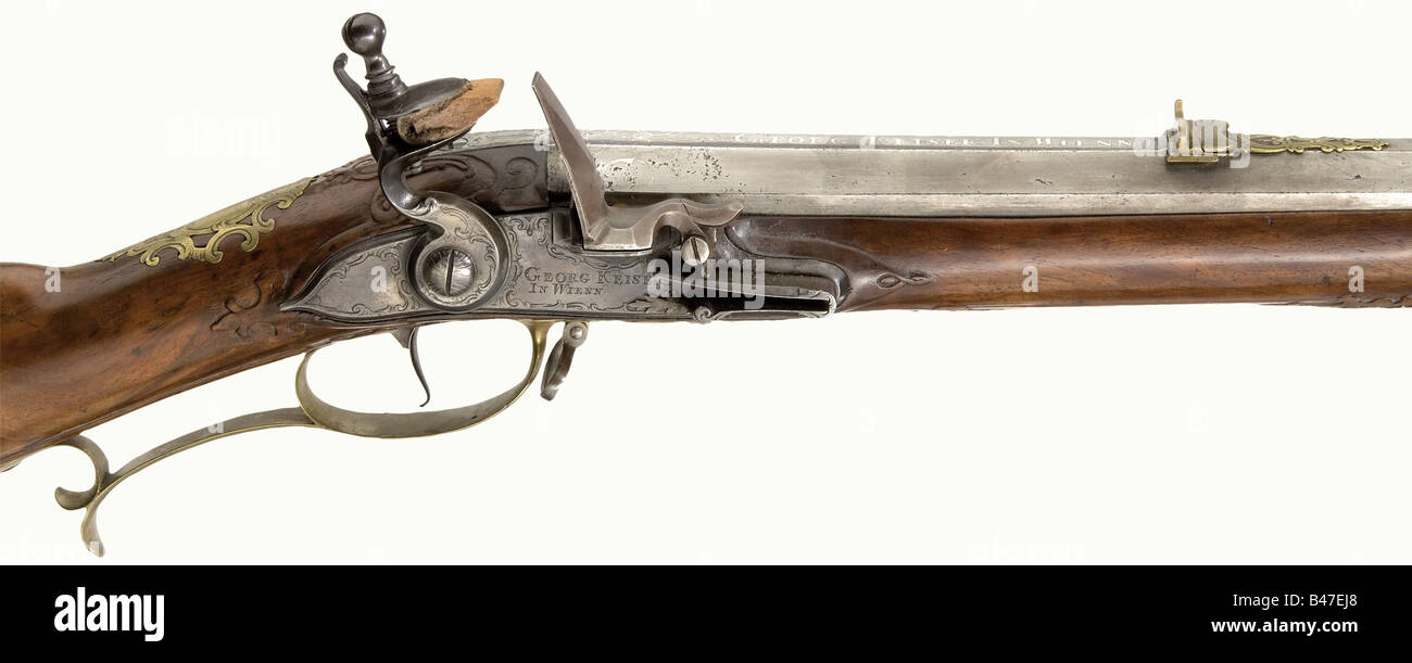 A flintlock rifle, Georg Keiser in Vienna, circa 1730. Heavy octagonal barrel with a slightly reduced diameter in the middle. Seven groove rifled bore in 17 mm calibre. Engraved dovetailed folding sights. Silver inlaid decorative scrolls on the breech and the base of the barrel with the signature 'Georg Keiser in Wienn'. Tang engraved with the number '1'. The lock bears finely engraved rocaille decoration. The action block cover is a replacement. Gold bushed vent. Beautifully figured, lightly carved walnut full stock. Small repair on the forearm. Patchbox. Fine, Stock Photo