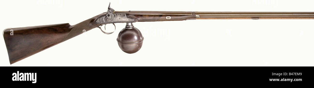 An air rifle with a pot reservoir, John Fotherby, Wakefield/GB, circa 1820. Three-stage Damascus twist barrel, the breech section octagonal then 16-sided, then round after a baluster, with beautiful bluing, blued sights and the inscription, 'Wakefield' inlaid in gold on the breech. Microgroove rifling in 10 mm calibre. The side lock with floral engraving, the lock plate signed, 'Fotherby'. Single set trigger. Walnut half stock with silver nosecap, checkered small of the stock, and engraved, blued iron furniture. Blued iron reservoir. Replacement ramrod with hor, Stock Photo