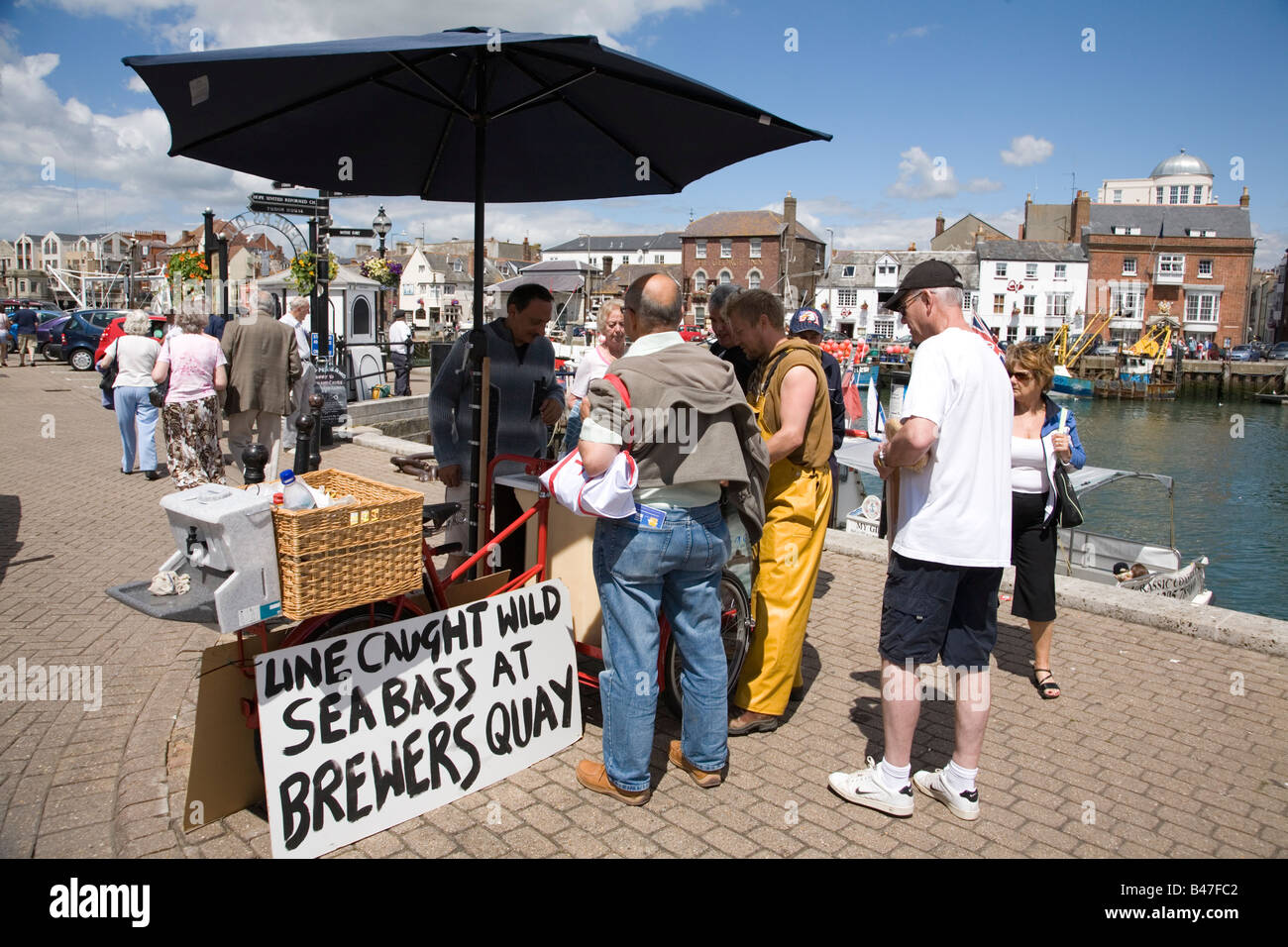 People buying fresh line caught sea bass off local man in Brewers Quay