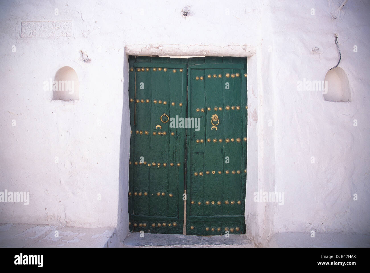 An old palmtrunk door with simple brass decor at Ghadamis, Libya Stock