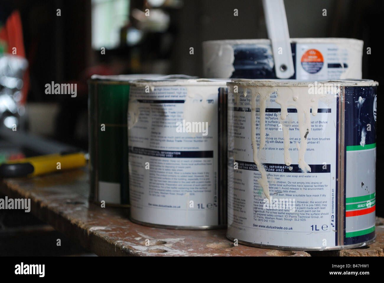 Old paint tins on bench in garage Stock Photo Alamy