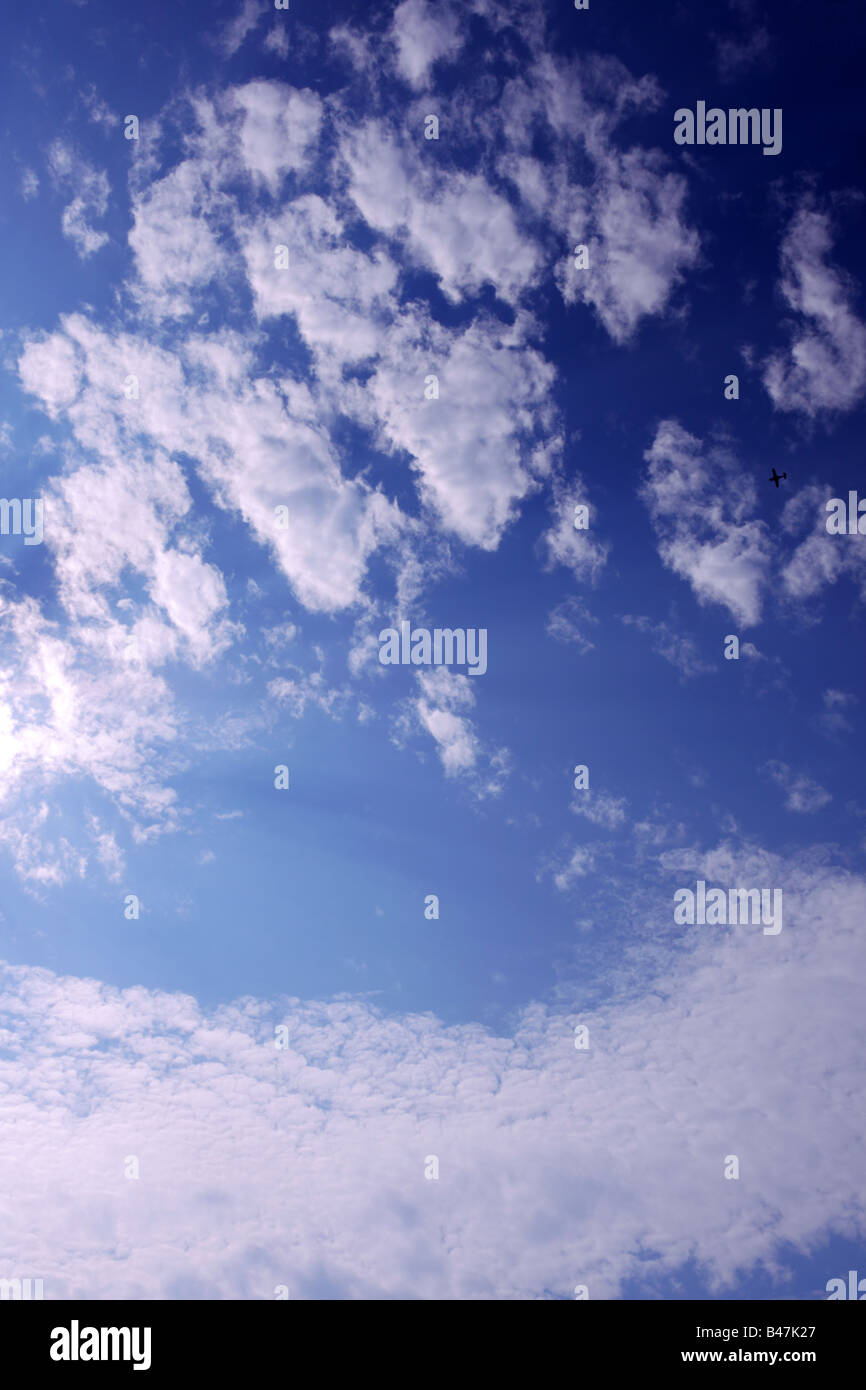 Small plane flying through Altocumulus clouds Stock Photo