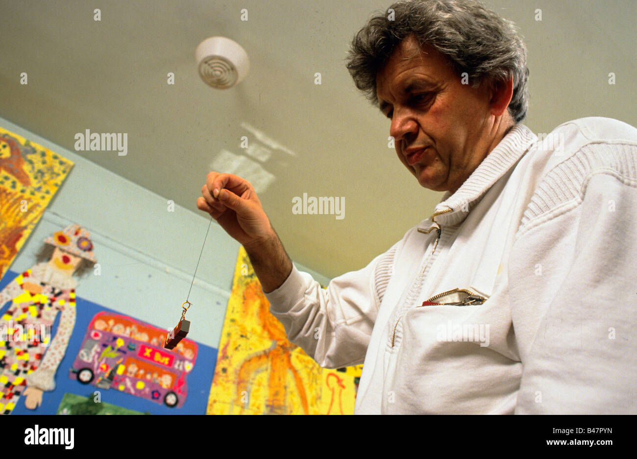 A primary school teacher explaining the priciples of magnetism to his class. Stock Photo