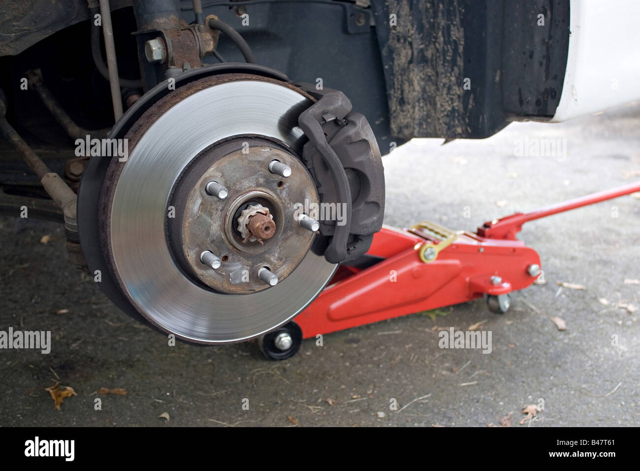 Closeup detail of the wheel assembly on a modern automobile The rim is removed showing the front rotor and caliper Stock Photo